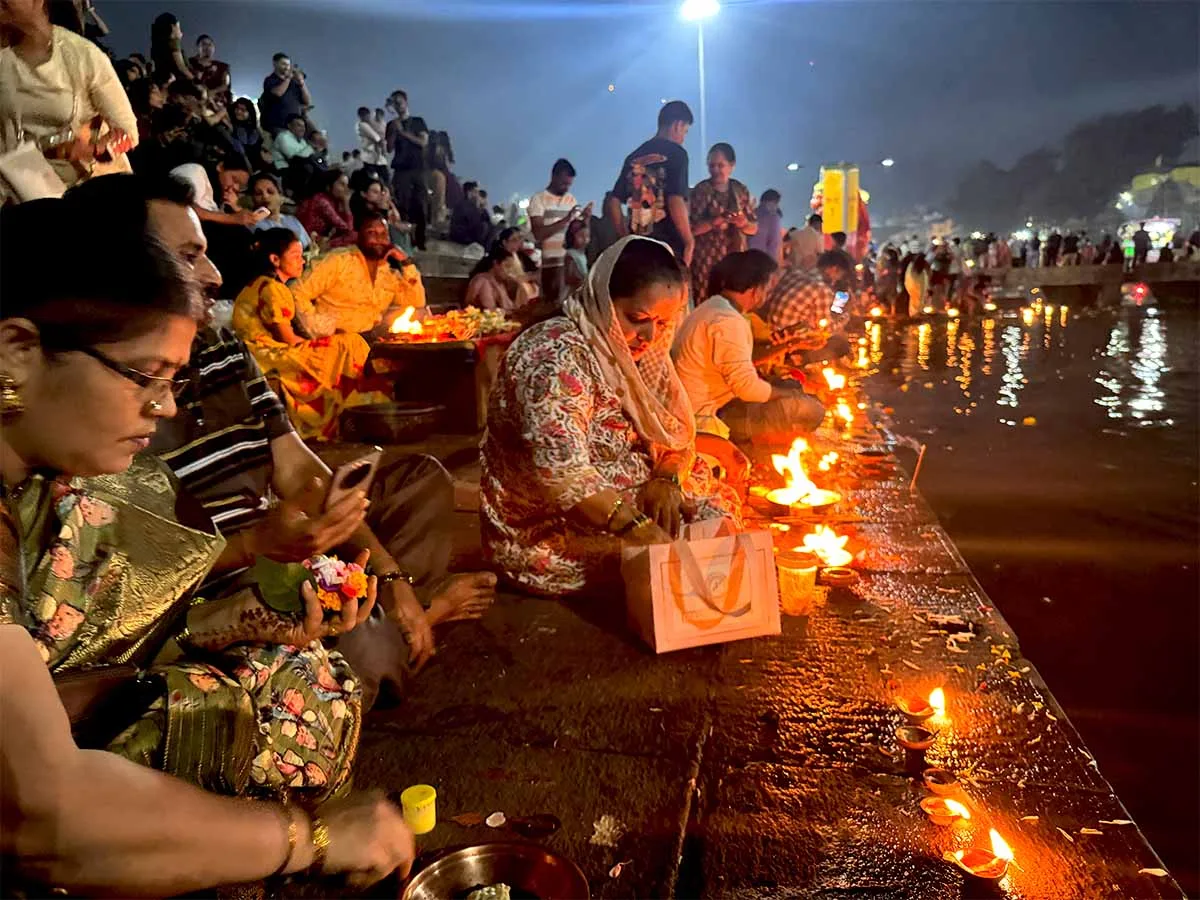Women lighting diyas on the ghats of the Godavari at Ramkund Nashik Maharashtra on Kartik Purnima