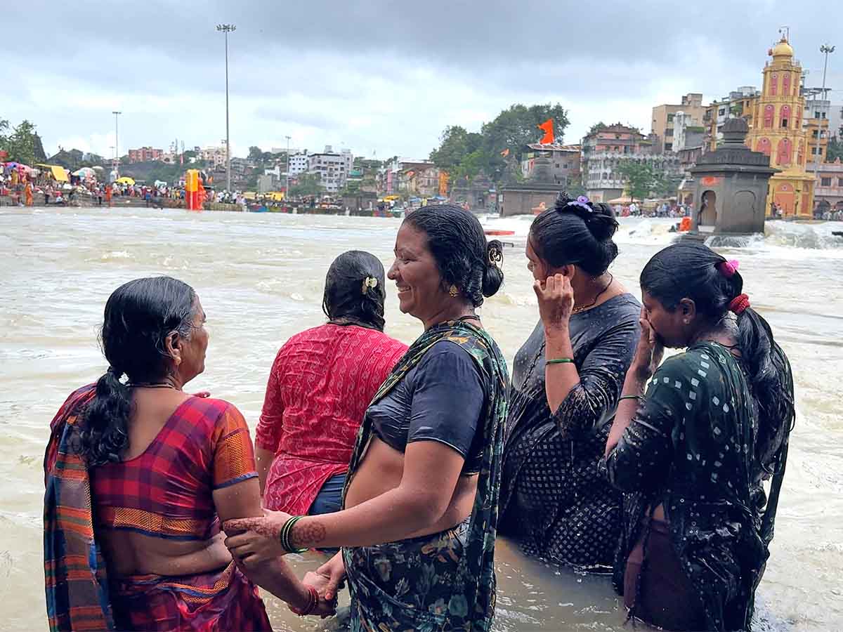 Women bathing in a flooded Godavari river at Ramkund in Nashik Maharashtra